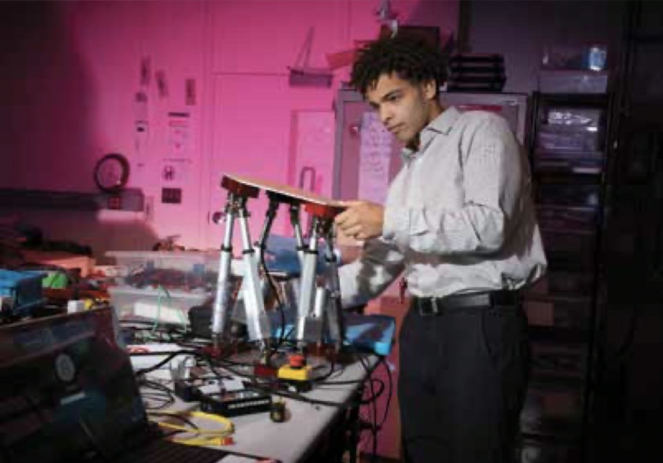 Brair (Tilboon) Elberier working at a motion platform in a lab at MIT Lincoln Laboratory